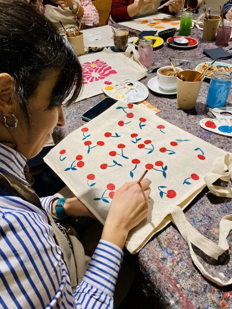 Participante pintando una tote bag de cerezas